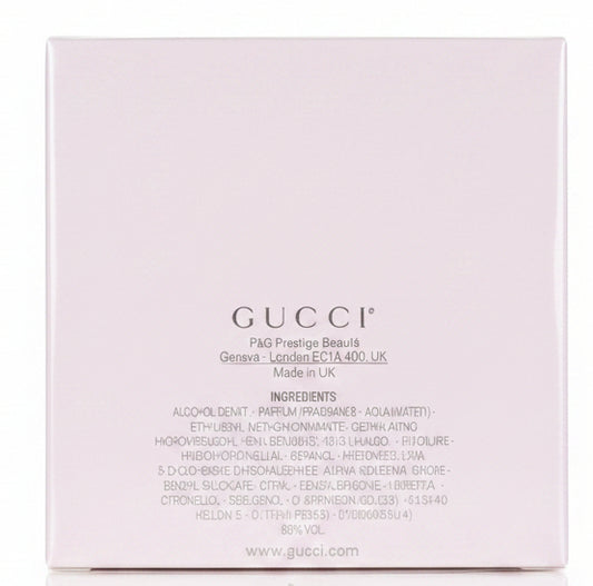 White Gucci box held by a hand on a red surface
