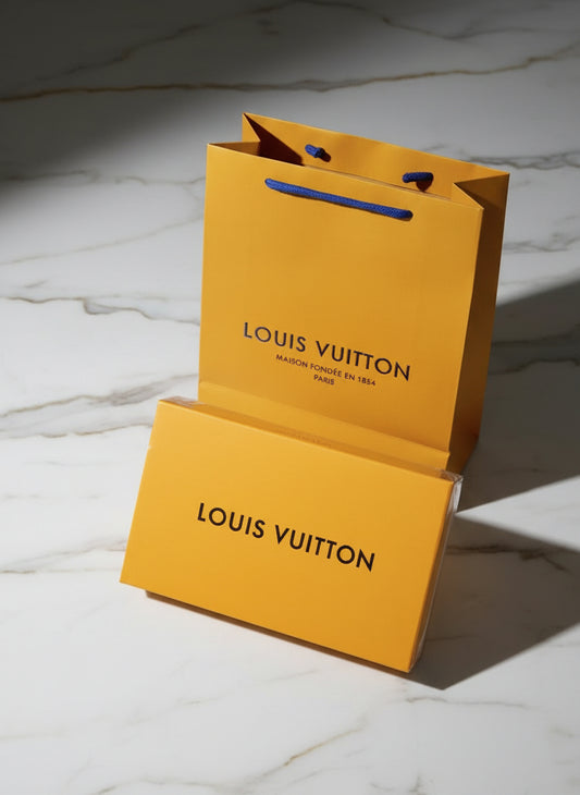 Louis Vuitton shopping bag and box on a marble surface