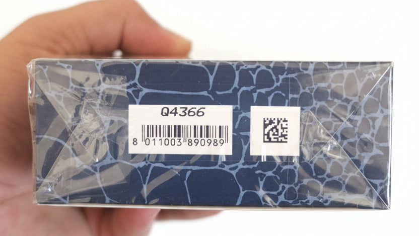 Product packaging with a label held by a hand against a red background