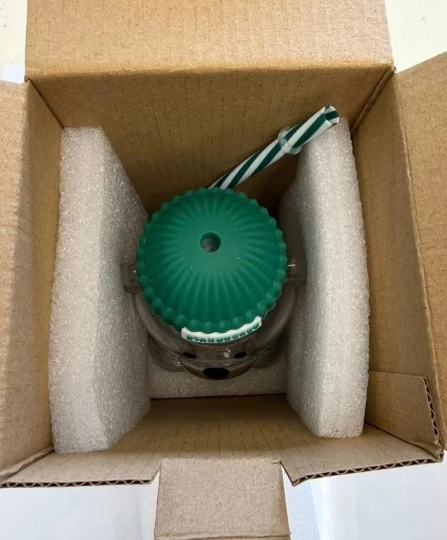 Green object in a cardboard box with bubble wrap
