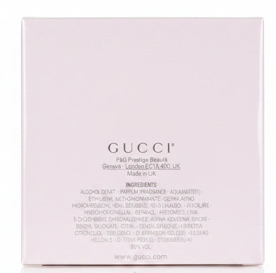 White Gucci box held by a hand on a red surface