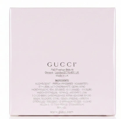 White Gucci box held by a hand on a red surface