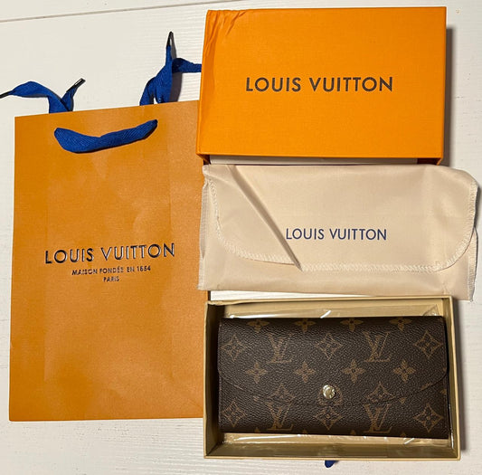 Louis Vuitton wallet, pouch, and shopping bag on a white background