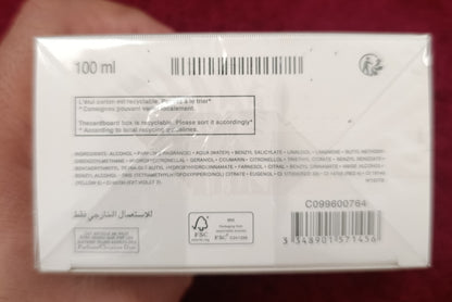White box with text and barcodes held by a hand against a red background