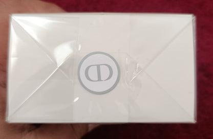 White rectangular product with a logo held by a hand on a red background