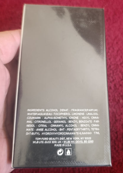 Product packaging held by a hand on a red background