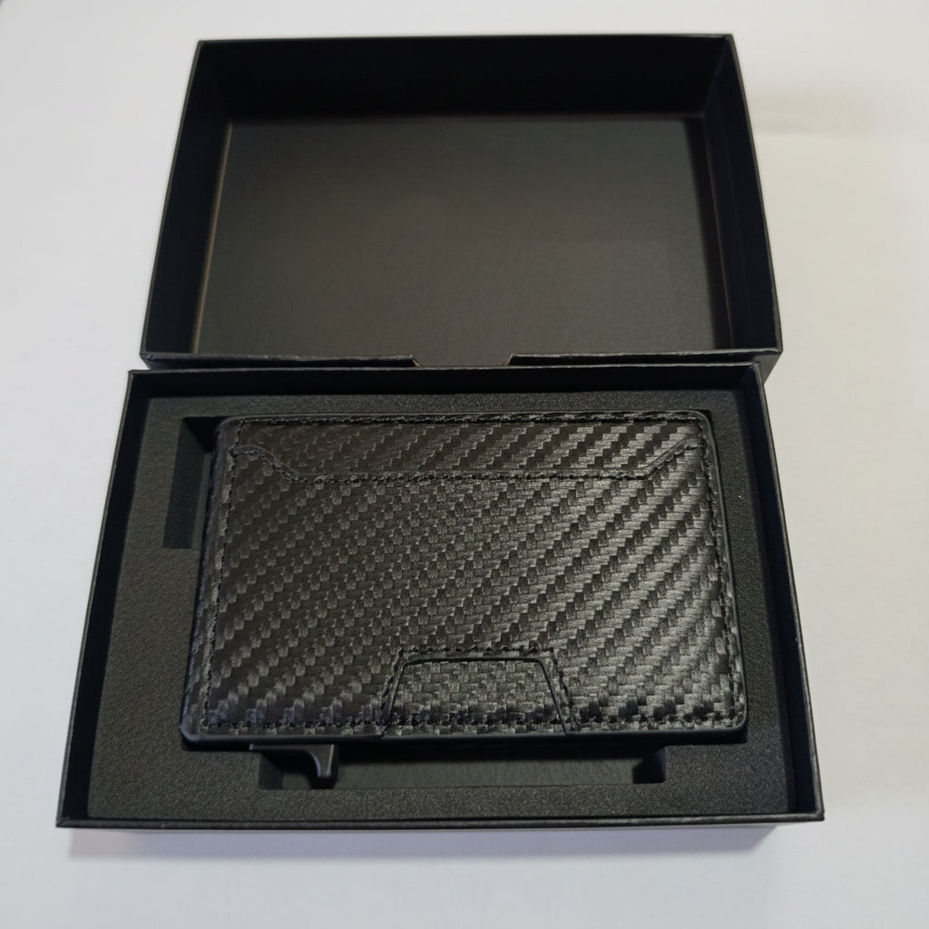 Black carbon fiber wallet in a black box on a white surface