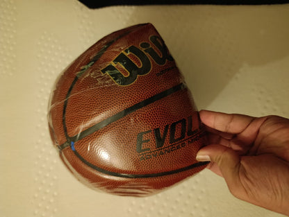 Basketball with 'Bull' branding held by a hand on a textured surface