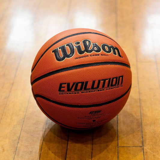 Basketball with Wilson Evolution branding on a wooden floor